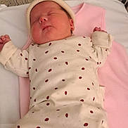 Kayla a rejoint le concours — aidez-le/la à gagner de superbes lots ! newborn, baby, sleeping, infant, crib, blanket, clothing, hat, socks, striped, ladybug_print, bed, resting, cute, soft_lighting, indoors, peaceful, child, person, portrait