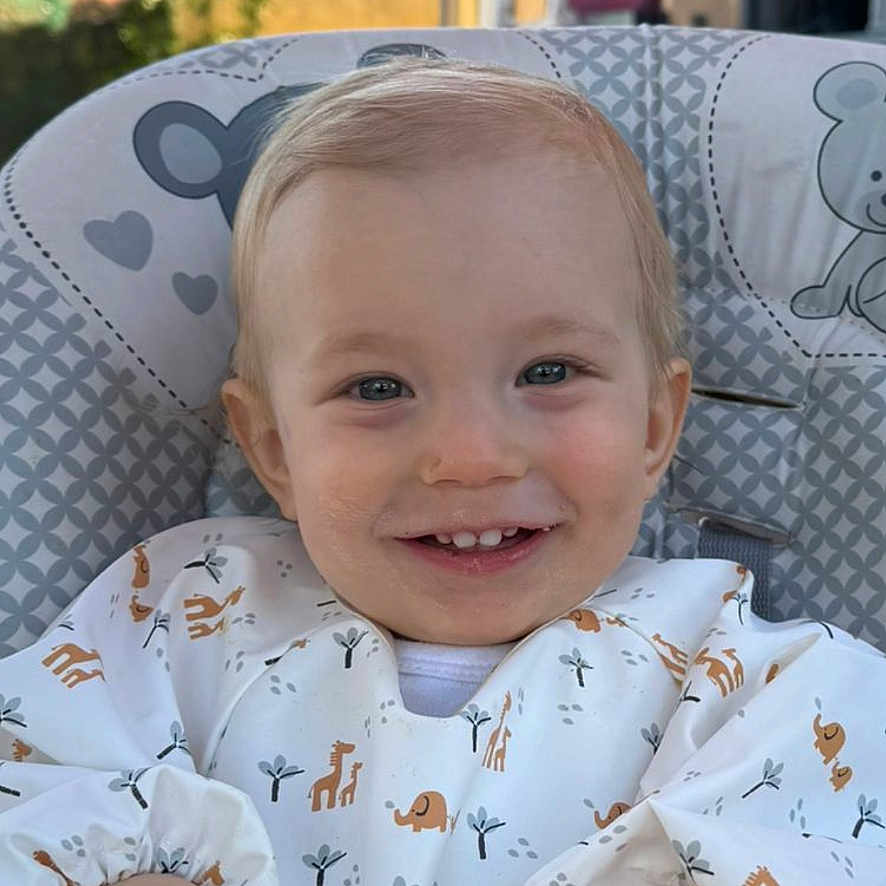 Enea a rejoint le concours — aidez-le/la à gagner de superbes lots ! baby, toddler, high_chair, smile, bib, food, crumbs, hands, face, outdoor, daylight, house, window, door, tree, sky, child, cute, happy, clothing