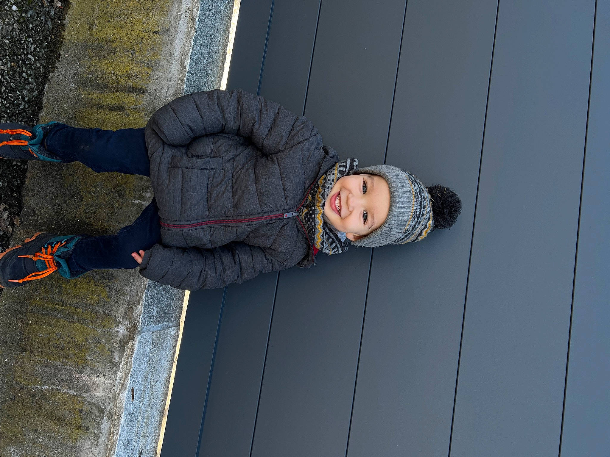 Kaëden participe au concours pour gagner de l'argent avec cette photo : asphalt, child, cobblestone, concrete, denim, electric_blue, eyewear, flooring, fun, headwear, joy, pattern, pedestrian, person, road_surface, shadow, sidewalk, sitting, smile, tree