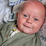 Léandre participe au concours pour gagner de l'argent avec cette photo : baby, smiling, blue_eyes, face, knit_cardigan, green_clothing, close_up, infant, child, soft_blanket, portrait, cute, happy, young_child, indoors, cozy, buttoned_clothing, head, skin, person