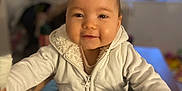 Elaïs participe au concours pour gagner de l'argent avec cette photo : baby, bodypart, clothing, coat, crawling, face, finger, hand, happy, head, jacket, knitwear, longsleeve, pants, person, photography, portrait, sitting, smile, sweater