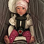 Emery is registered to the contest to win money with this photo: baby, infant, car_seat, pink_hat, bow, clothing, face, child, cute, looking_at_camera, safety_harness, foot, star_pattern, warm, indoor, person, adorable, newborn, seated, cozy