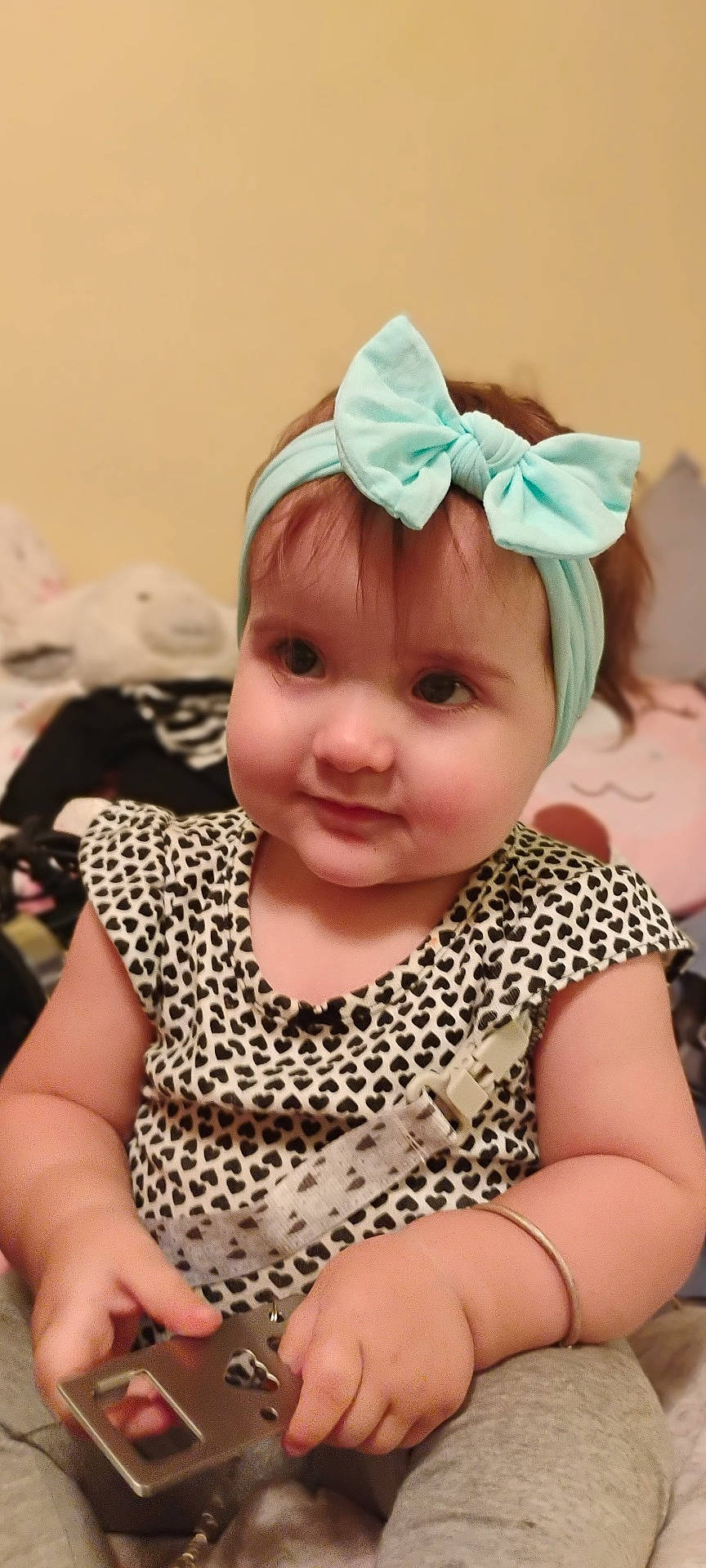 Helena joined the competition — help win amazing prizes! baby, bow, bracelet, casual_clothing, child, closeup, curious, cute, headband, heart_pattern, indoor, metallic_object, patterned_clothing, plush_toy, portrait, sitting, soft_lighting, toddler, toy, young_child