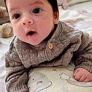 Ryan joined the competition — help win amazing prizes! baby, infant, face, eyes, open_mouth, hand, fist, pillow, animal_print, sweater, button, blanket, soft, cute, indoors, child, expression, clothing, portrait, closeup
