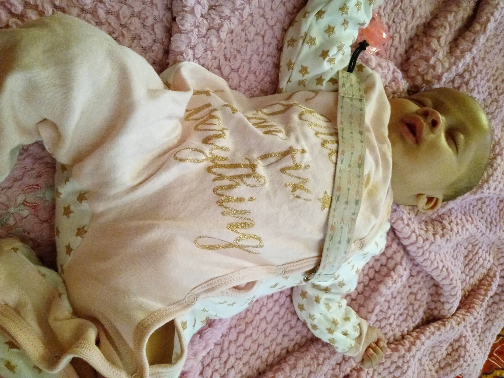 Nariah is registered to the contest to win money with this photo: arm, baby_products, baby_toddler_clothing, bedding, comfort, doll, dress, fawn, hand, head, headgear, human_body, linens, pattern, person, pink, skin, sleeve, textile, toy