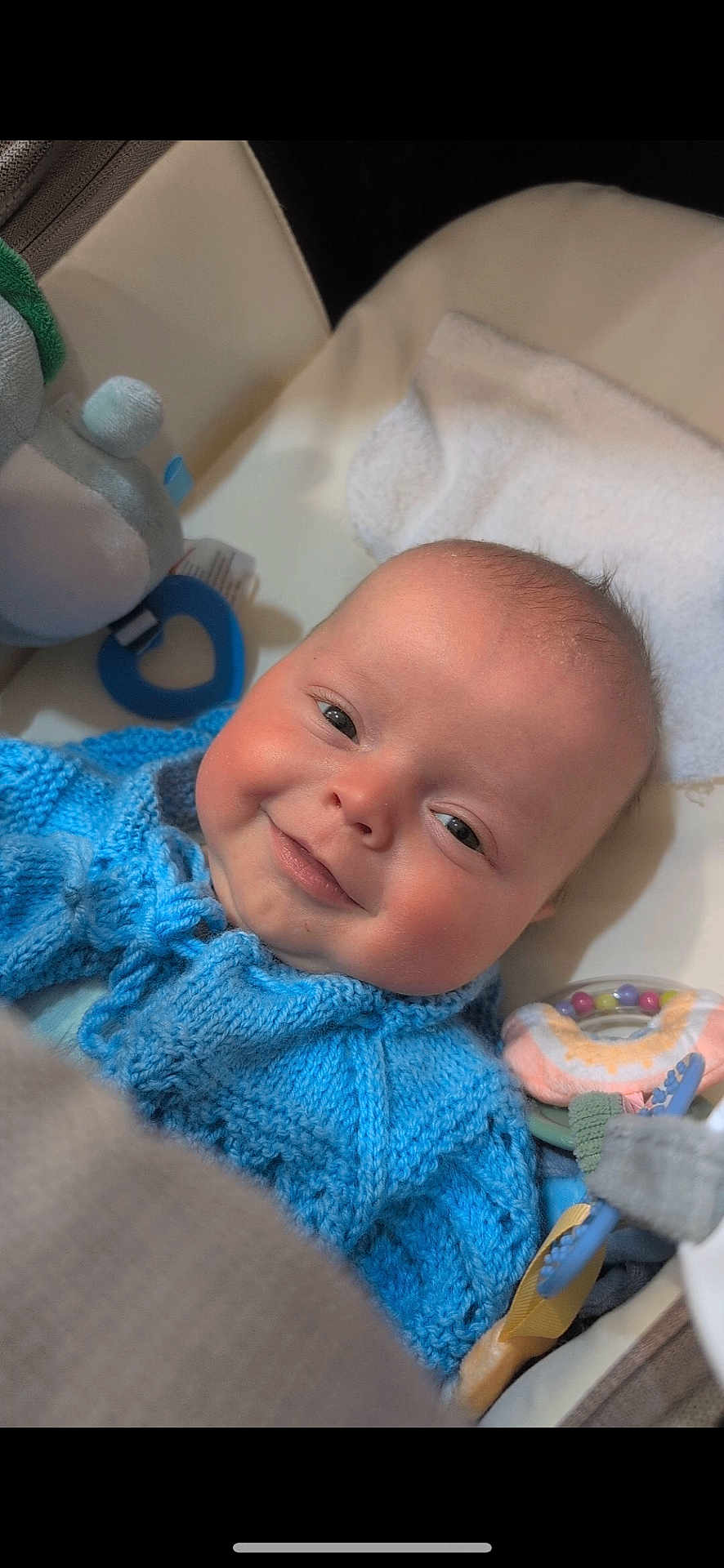 Lincoln joined the competition — help win amazing prizes! baby, smiling, blue_sweater, knitted_clothing, baby_seat, toy, towel, face, infant, cute, child, indoor, closeup, happy, soft_texture, colorful, comfort, newborn, portrait, resting