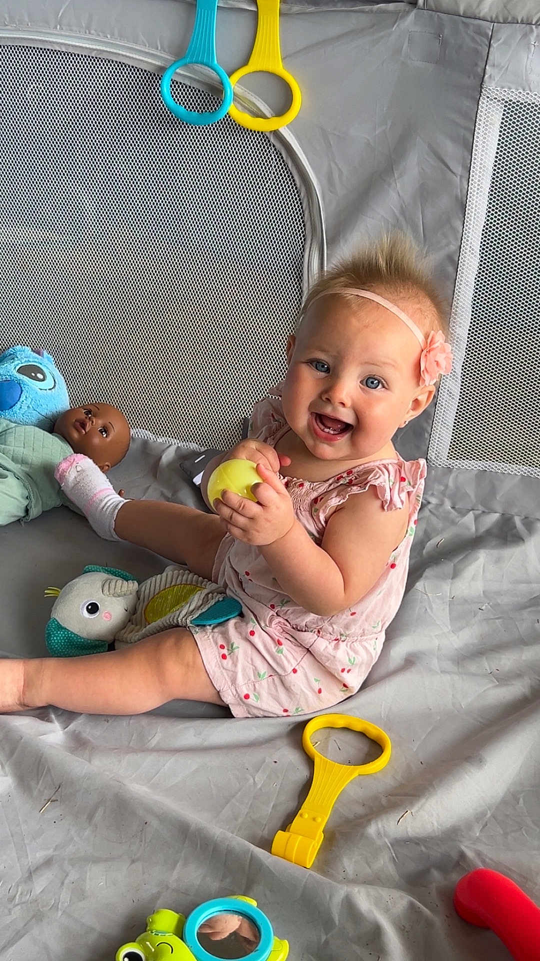 Jessaleena joined the competition — help win amazing prizes! baby, child, smiling, playpen, toy, doll, yellow_ball, pink_outfit, headband, flower, mesh, fabric, blue_toy, red_toy, sitting, happy, cute, indoor, play, infant