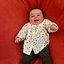 Emy a rejoint le concours — aidez-le/la à gagner de superbes lots ! baby, smiling, infant, heart_pattern, white_shirt, black_pants, orange_blanket, happy, cute, child, portrait, sitting, clothing, cheerful, young, fun, joy, face, skin, person