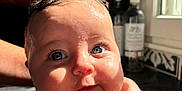 Emy participe au concours pour gagner de l'argent avec cette photo : baby, child, wet_skin, blue_eyes, bath, hand, bottle, window, sunlight, kitchen, person, infant, closeup, skin, face, curious, water, holding, background, indoor