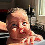 baby, child, wet_skin, blue_eyes, bath, hand, bottle, window, sunlight, kitchen, person, infant, closeup, skin, face, curious, water, holding, background, indoor
