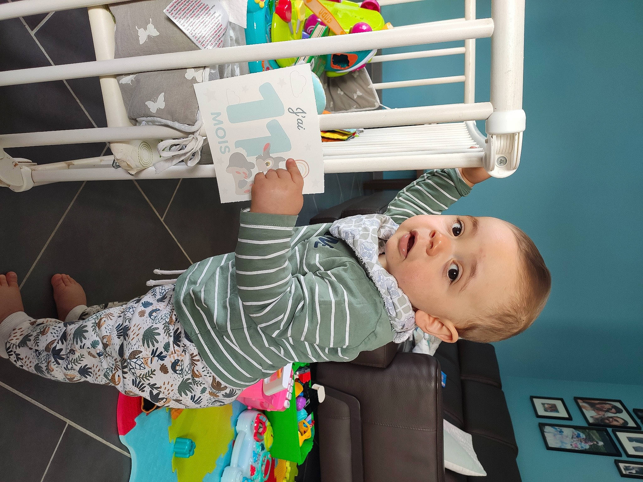 Noé participe au concours pour gagner de l'argent avec cette photo : baby, baby_products, baby_safety, baby_toddler_clothing, baby_toys, bed, child, comfort, fun, human_body, leg, nursery, pattern, person, play, room, shelf, smile, t_shirt, toddler