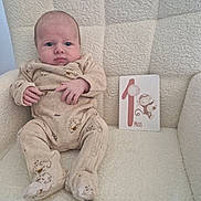 Adrian participe au concours pour gagner de l'argent avec cette photo : baby, infant, onesie, chair, milestone_card, monkey_illustration, cute, cozy, portrait, child, soft_texture, beige, cream_color, sitting, indoor, person, young_child, small_hands, cute_expression, comfortable