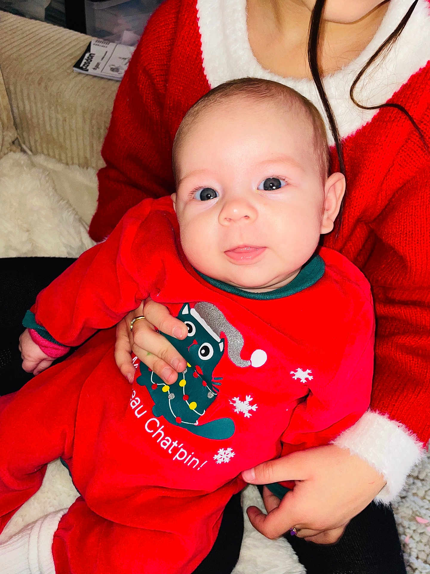 Chéra participe au concours pour gagner de l'argent avec cette photo : baby, infant, child, person, red_clothing, holiday_outfit, cat_graphic, hand, sweater, cozy, indoor, portrait, cute, festive, smiling, cute_face, warm, comfort, seated, family