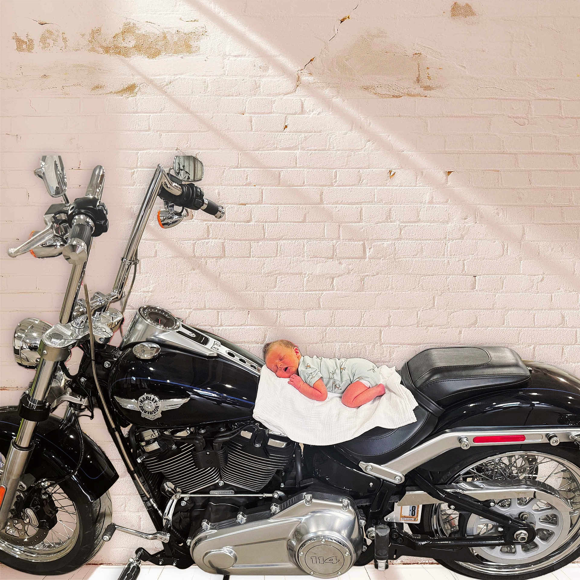 Huxley joined the competition — help win amazing prizes! baby, newborn, motorcycle, harley_davidson, black, white_brick_wall, blanket, sleeping, chrome, engine, wheel, handlebars, seat, shadow, indoor, cute, peaceful, small, infant, vehicle