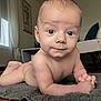 baby, infant, child, naked, blue_eyes, lying_down, carpet, rug, indoor, furniture, chair, window, curtains, wooden_floor, skin, hands, face, portrait, home, cozy