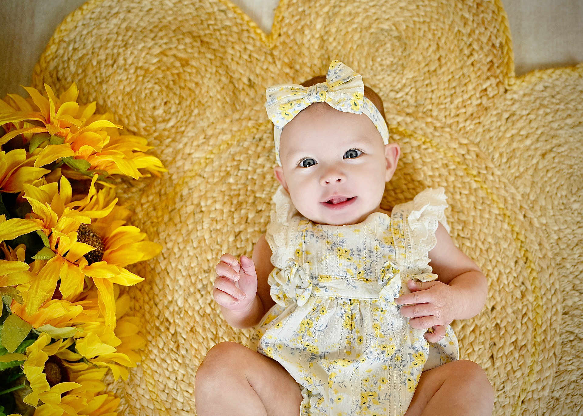 Mckinlyn joined the competition — help win amazing prizes! baby, infant, smile, headband, flower, woven_mat, sunflowers, yellow, cute, child, portrait, laying_down, clothing, happy, skin, hand, face, eyes, indoor, decor