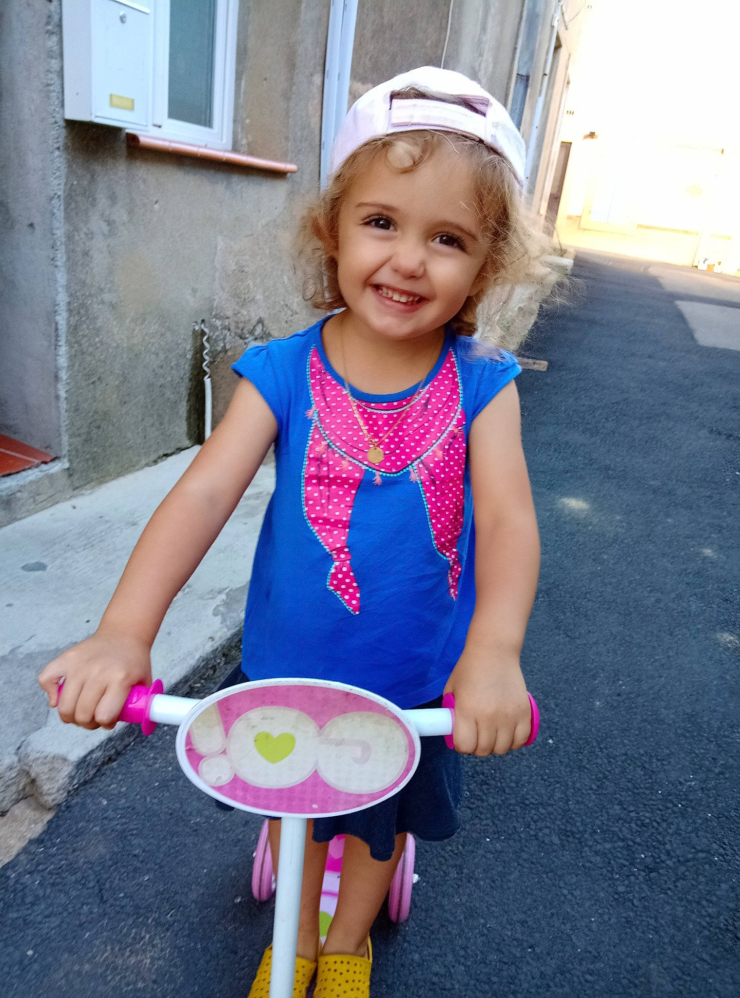 Stella a rejoint le concours — aidez-le/la à gagner de superbes lots ! baby_toddler_clothing, blue, child, clothing, dress, electric_blue, facial_expression, fun, happy, joy, leisure, magenta, party_supply, person, personal_protective_equipment, pink, recreation, smile, standing, t_shirt