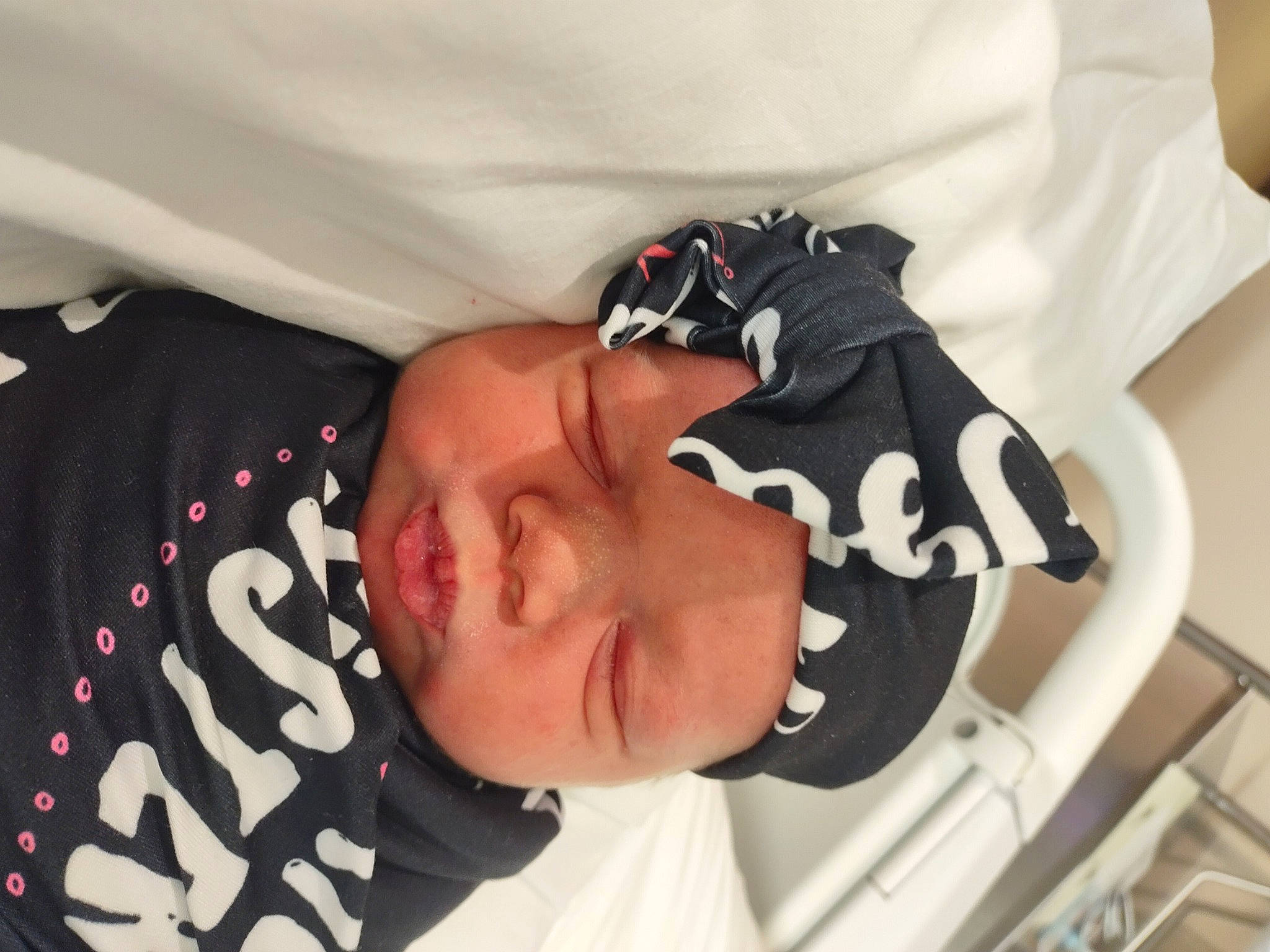 Bria is registered to the contest to win money with this photo: baby, carmine, child, comfort, elbow, eyelash, eyewear, font, hat, headwear, linens, pattern, person, room, sleeve, sunglasses, t_shirt, toddler, wrist