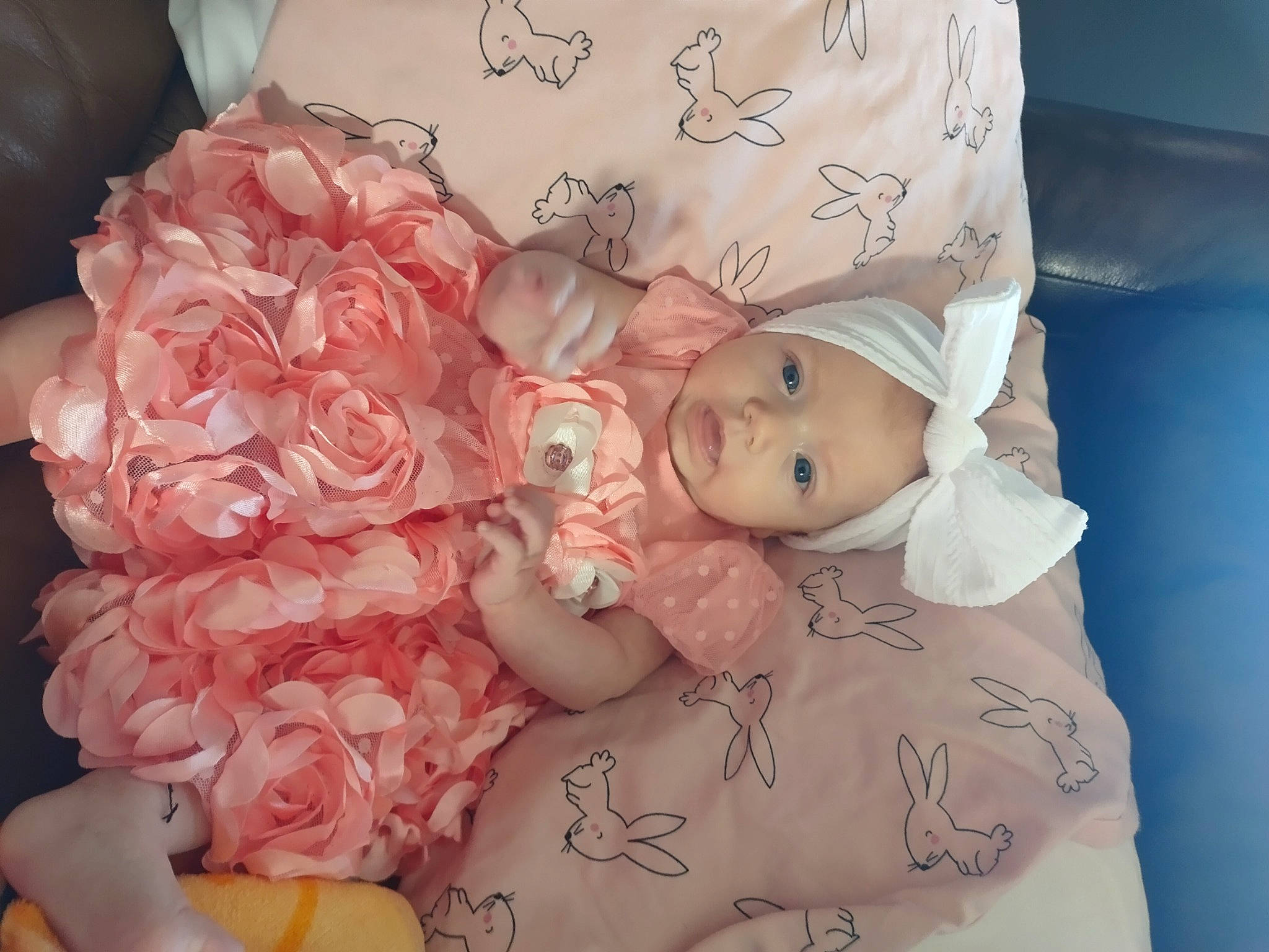 Bria is registered to the contest to win money with this photo: baby, baby_toddler_clothing, cut_flowers, dress, eyelash, flower, hand, head, headpiece, headwear, nail, peach, person, petal, pink, plant, rose, rose_family, rose_order, skin