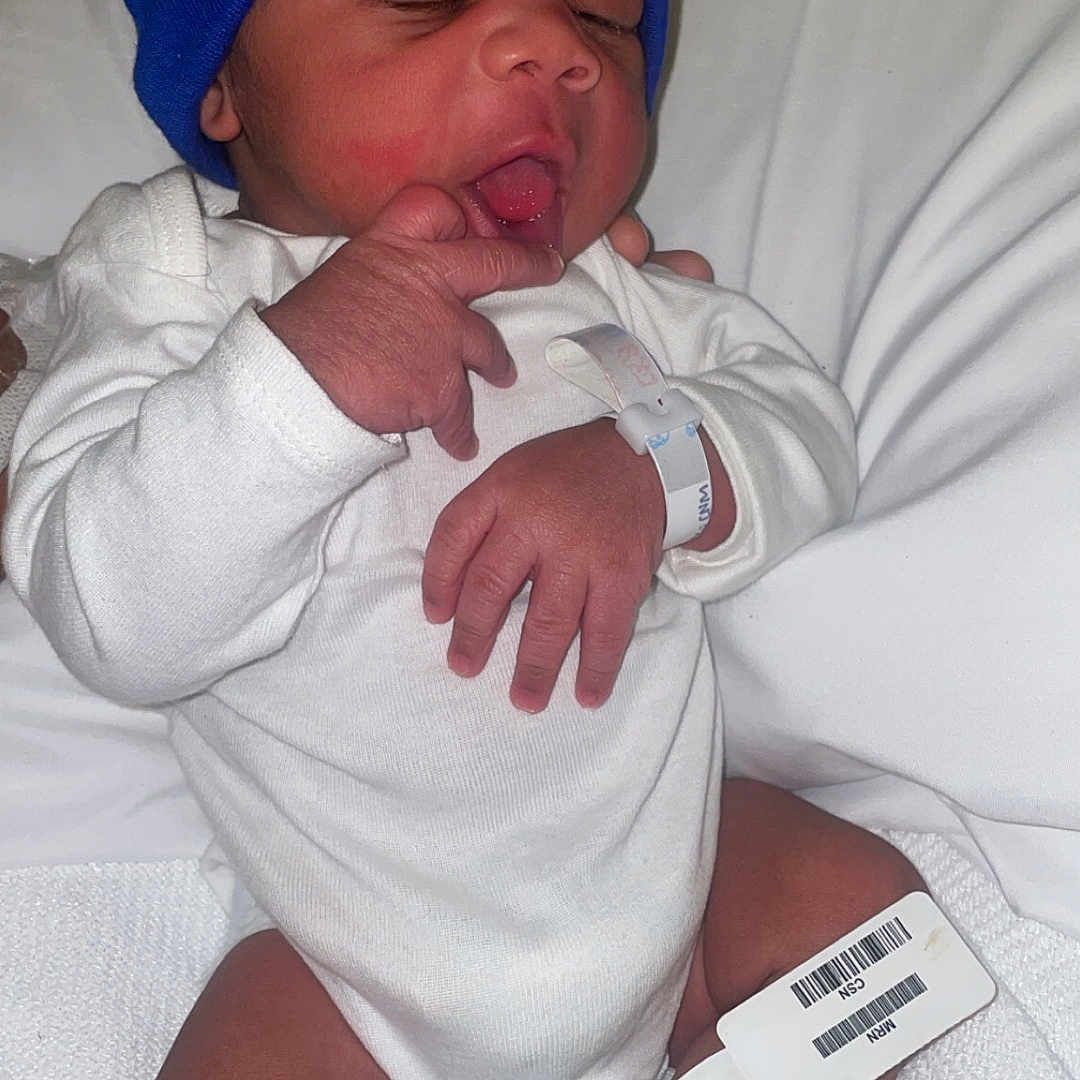 Quameire is registered to the contest to win money with this photo: architecture, baby, baseballcap, bed, bodypart, building, cap, clothing, face, finger, furniture, glove, hand, hat, head, hospital, newborn, person, photography, portrait