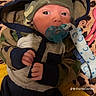 baby, infant, pacifier, hoodie, hat, camo_pattern, blanket, leopard_print, yellow_quilt, clothing, cute, face, hand, person, indoors, lying_down, blue, green, newborn, child