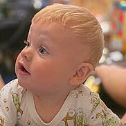 Parker is registered to the contest to win money with this photo: baby, blonde_hair, blue_eyes, child, close_up, curious_expression, cute, face, indoor, infant, patterned_clothing, person, portrait, short_hair, side_view, skin, smiling, soft_lighting, toddler, young_child