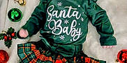 Amelia is registered to the contest to win money with this photo: baby, blanket, celebration, child, christmas, cute, decorations, festive, green_clothing, headband, holiday, holiday_theme, infant, lying_down, ornaments, plaid_skirt, portrait, red_socks, smiling, soft_texture