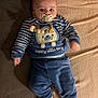 Naël a rejoint le concours — aidez-le/la à gagner de superbes lots ! baby, infant, pacifier, blue_clothing, striped_sleeves, bear_design, happy_little_boy_text, soft_surface, blanket, couch, cozy, child, cute, lying_down, indoors, warm_clothing, smiling_eyes, head, small_hands, footwear
