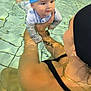 Naël participe au concours pour gagner de l'argent avec cette photo : baby, woman, swimming_pool, water, swim_cap, swimsuit, child, adult, holding, reflection, indoor_pool, tattoo, earrings, necklace, people, floating, tile_floor, yellow_float, swimming, lesson