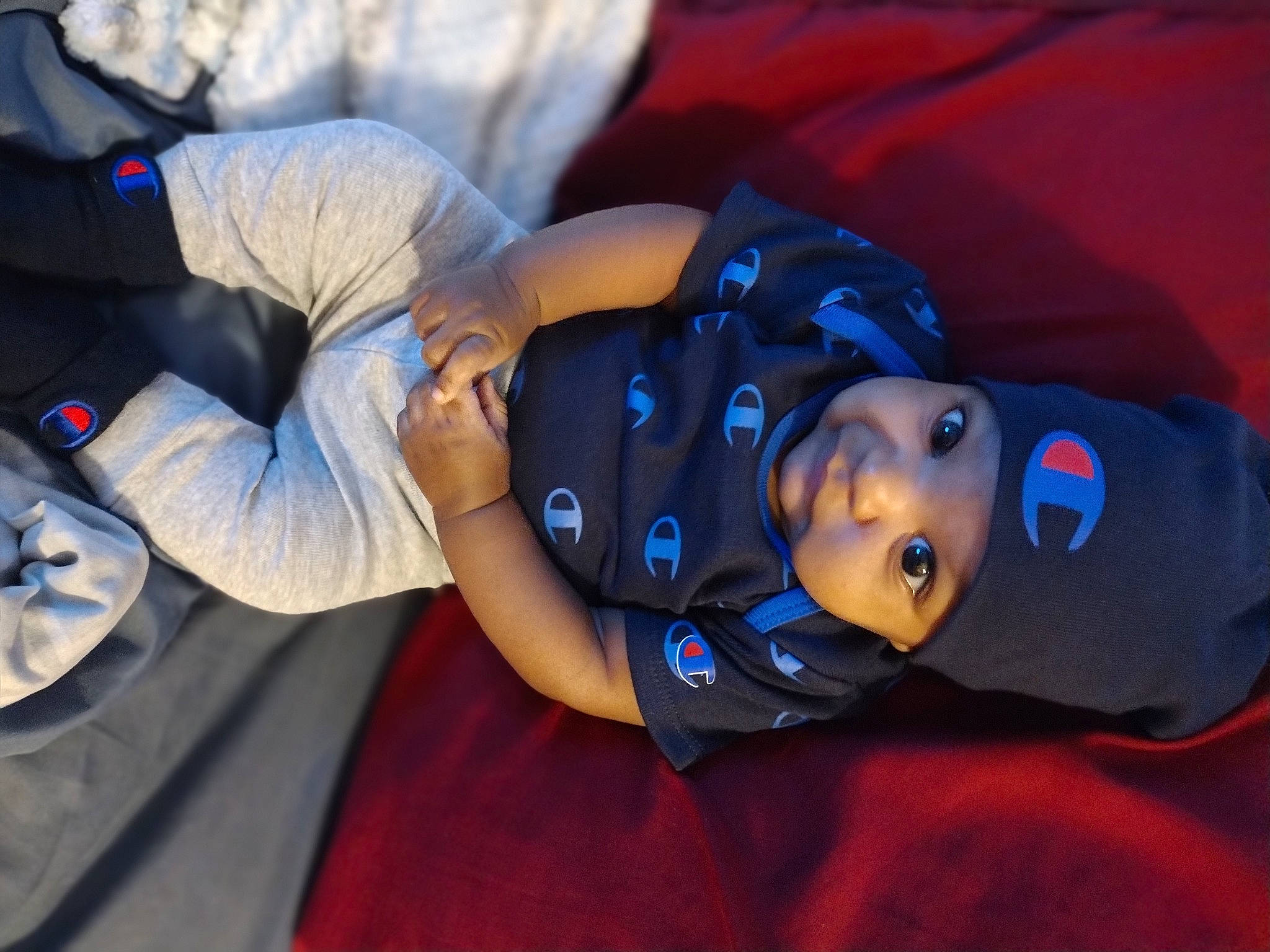 Legend is registered to the contest to win money with this photo: baby, child, elbow, electric_blue, fun, hat, headwear, human_leg, leisure, mouth, person, plant, sitting, toddler, tree