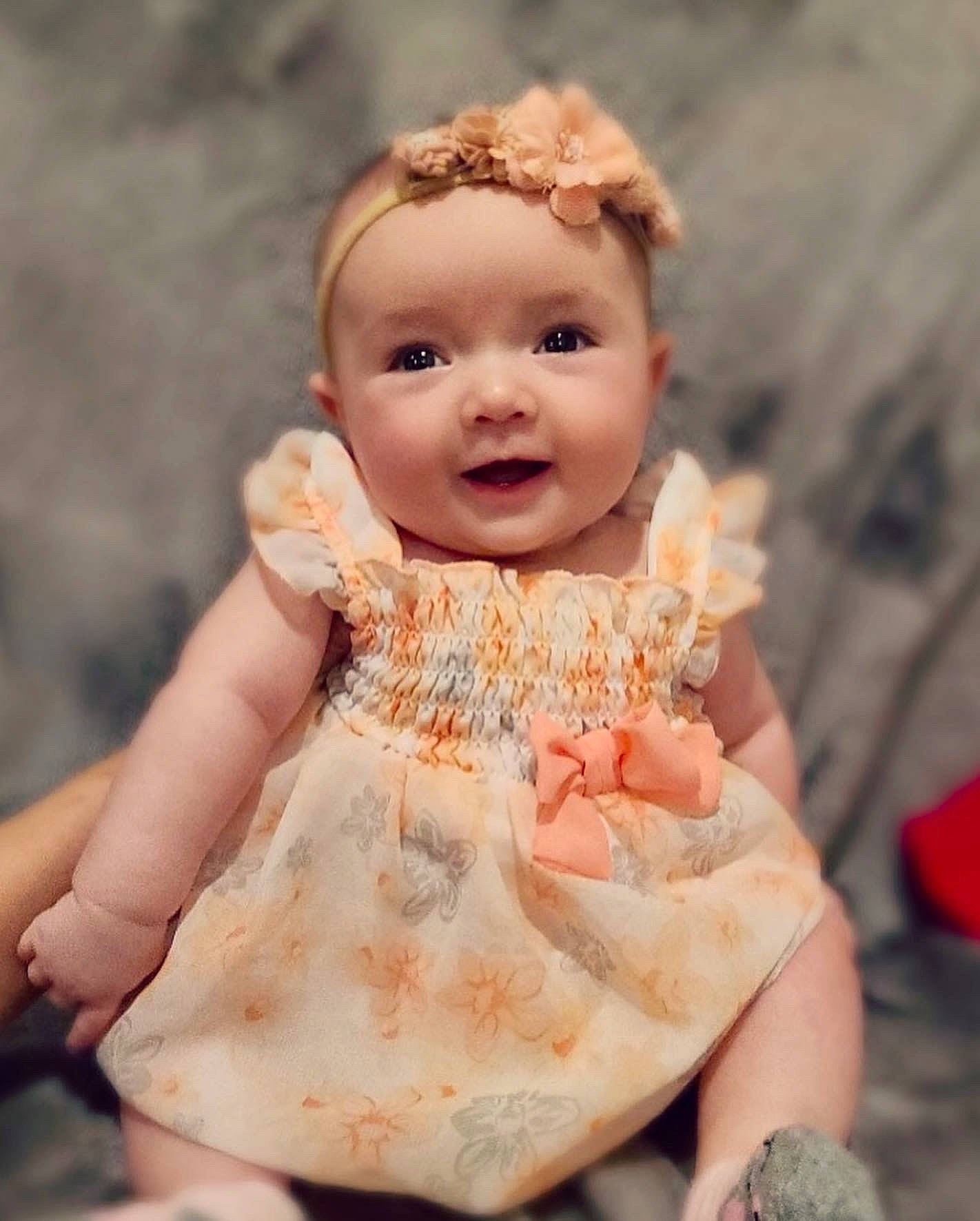 Aubrie is registered to the contest to win money with this photo: art, baby, baby_toddler_clothing, cheek, dress, flash_photography, fun, gesture, happy, head, headwear, human_body, nail, peach, people_in_nature, person, smile, thumb, toddler, toy