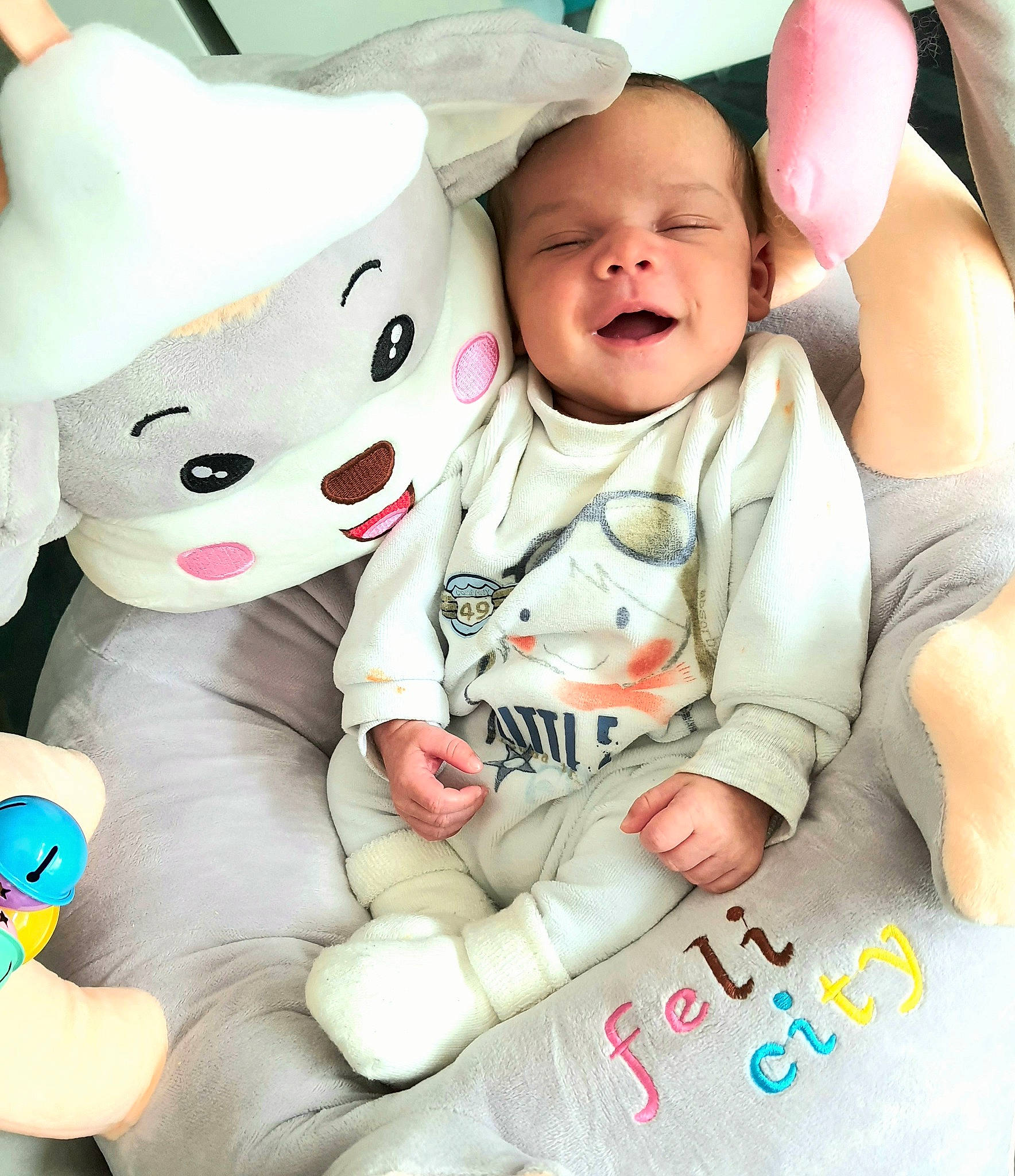 Jérémy a rejoint le concours — aidez-le/la à gagner de superbes lots ! baby, baby_sleeping, baby_toddler_clothing, child, comfort, gesture, happy, linens, mouth, pattern, person, pink, product, sitting, skin, sleeve, smile, textile, thumb, toddler