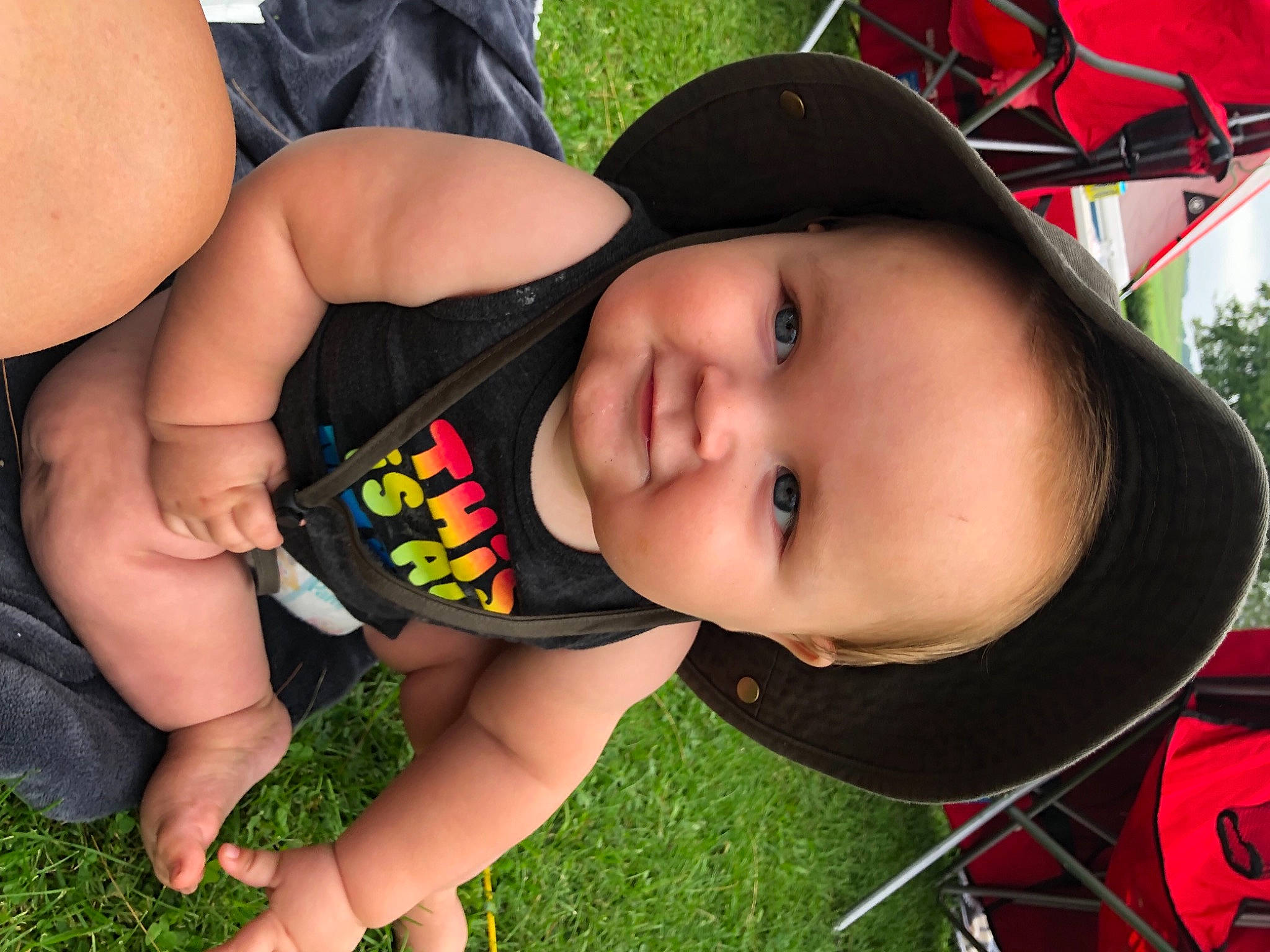 Arlo is registered to the contest to win money with this photo: baby, cap, cool, facial_expression, fun, grass, happy, hat, head, leisure, lip, mouth, nose, person, plant, product, skin, smile, sun_hat, toddler