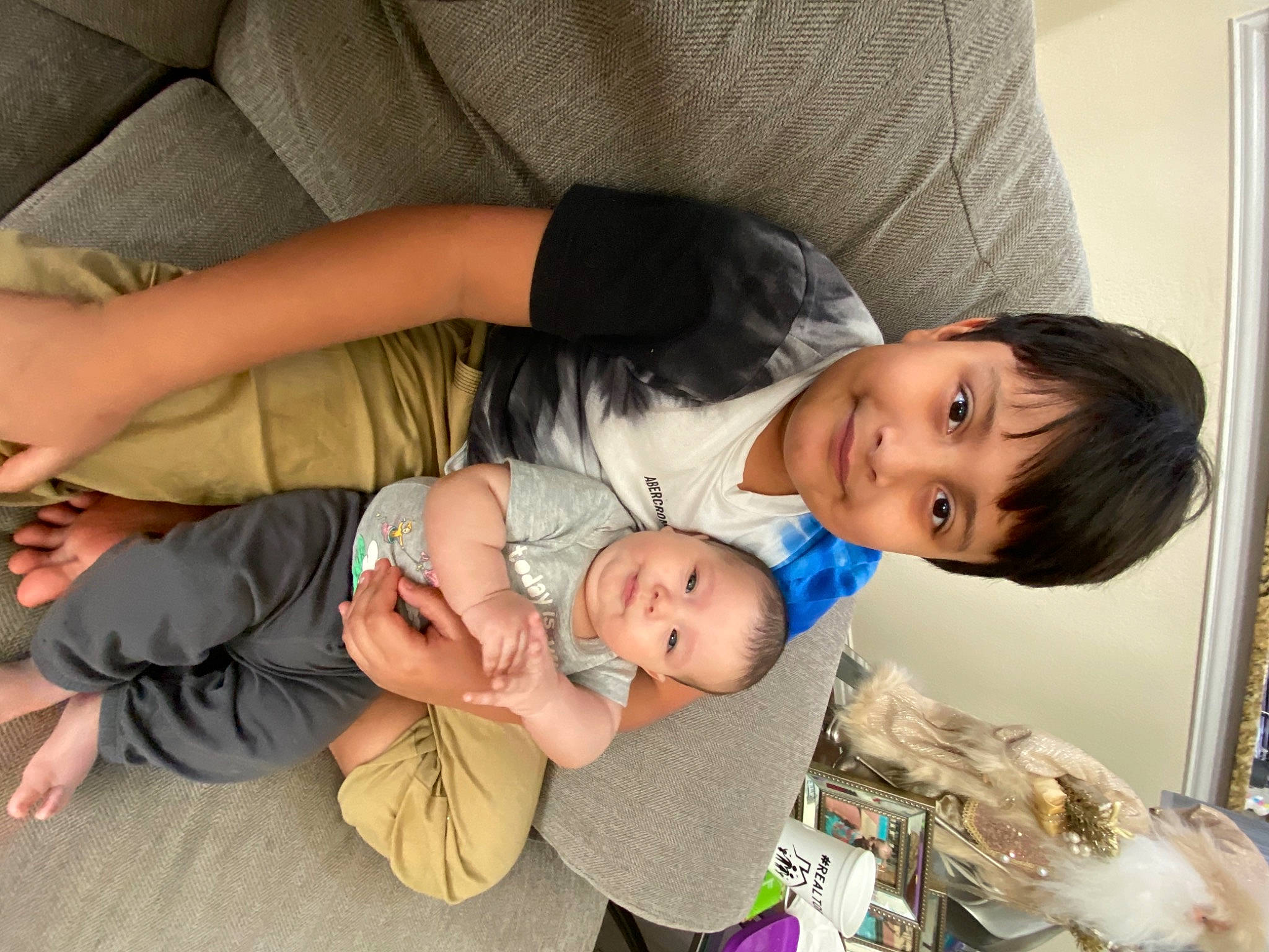 Noah is registered to the contest to win money with this photo: baby, baby_toddler_clothing, child, comfort, couch, elbow, foot, joy, lap, living_room, person, stomach, toddler, toe, wrist