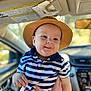 baby, child, hat, striped_shirt, blue, white, smiling, indoors, car_interior, person, hands, cute, portrait, young, headwear, casual_clothing, seatbelt, window, daylight, happy