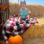 Nenase is registered to the contest to win money with this photo: autumn, blanket, blue_sky, child, crate, cute, fall, farm, green_clothing, hay_bale, nature, outdoor, plaid, portrait, pumpkin, sandals, seasonal, sunny, toddler, wood