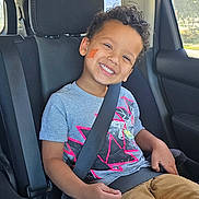 Arquette joined the competition — help win amazing prizes! child, smiling, car_seat, seatbelt, vehicle, window, casual_clothing, face_sticker, happy, curly_hair, boy, indoor, sunlight, safety, car_interior, seat, transportation, portrait, young, kid