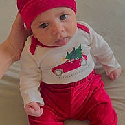 Yazeed joined the competition — help win amazing prizes! baby, infant, child, red_clothing, hat, tongue_out, cute, hand, sitting, indoors, soft_surface, playful, festive, long_sleeve_shirt, pants, person, portrait, young_child, cozy, expression