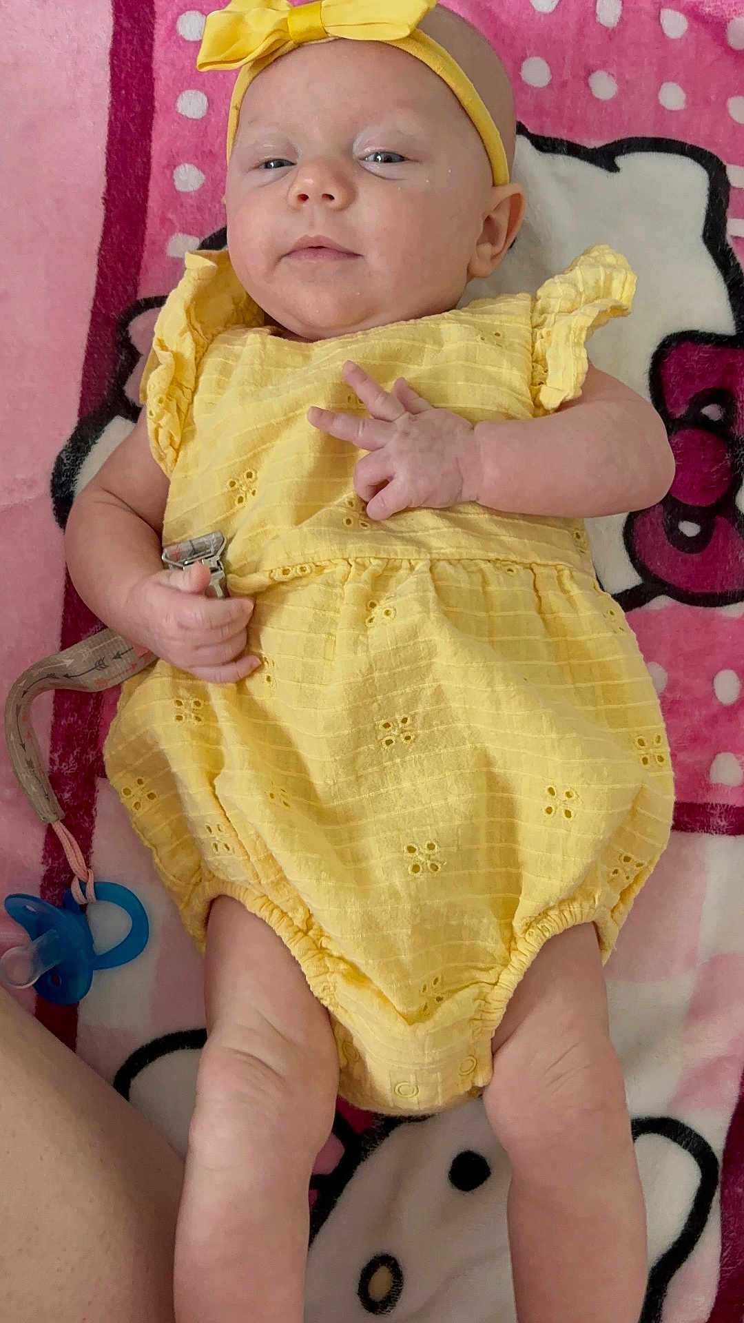 Kaia joined the competition — help win amazing prizes! baby, infant, yellow_dress, headband, pacifier, blanket, pink, white, polka_dots, cute, lying_down, hand_gesture, soft_texture, indoors, child, human, legs, skin, clothing, accessory