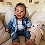 Raïley a rejoint le concours — aidez-le/la à gagner de superbes lots ! toddler, child, denim_jacket, jeans, smiling, barefoot, plush_toy, bunny, couch, cozy, indoor, home_decor, happy, curly_hair, portrait, seated, soft_toys, furniture, casual_clothing, baby
