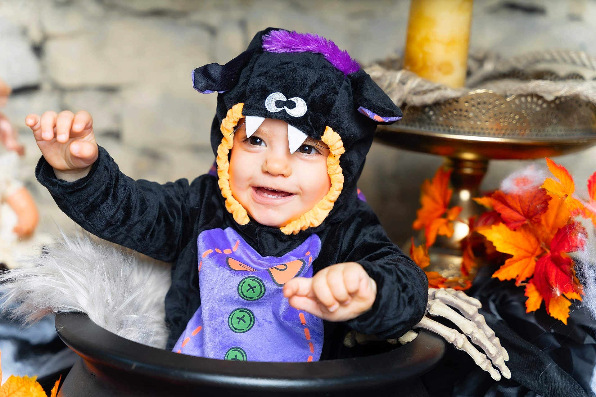 Mia participe au concours pour gagner de l'argent avec cette photo : toddler, child, costume, halloween, monster, cauldron, autumn_leaves, decorations, smile, happy, indoor, face, hand, purple, black_clothing, playful, cute, holiday, festive, celebration