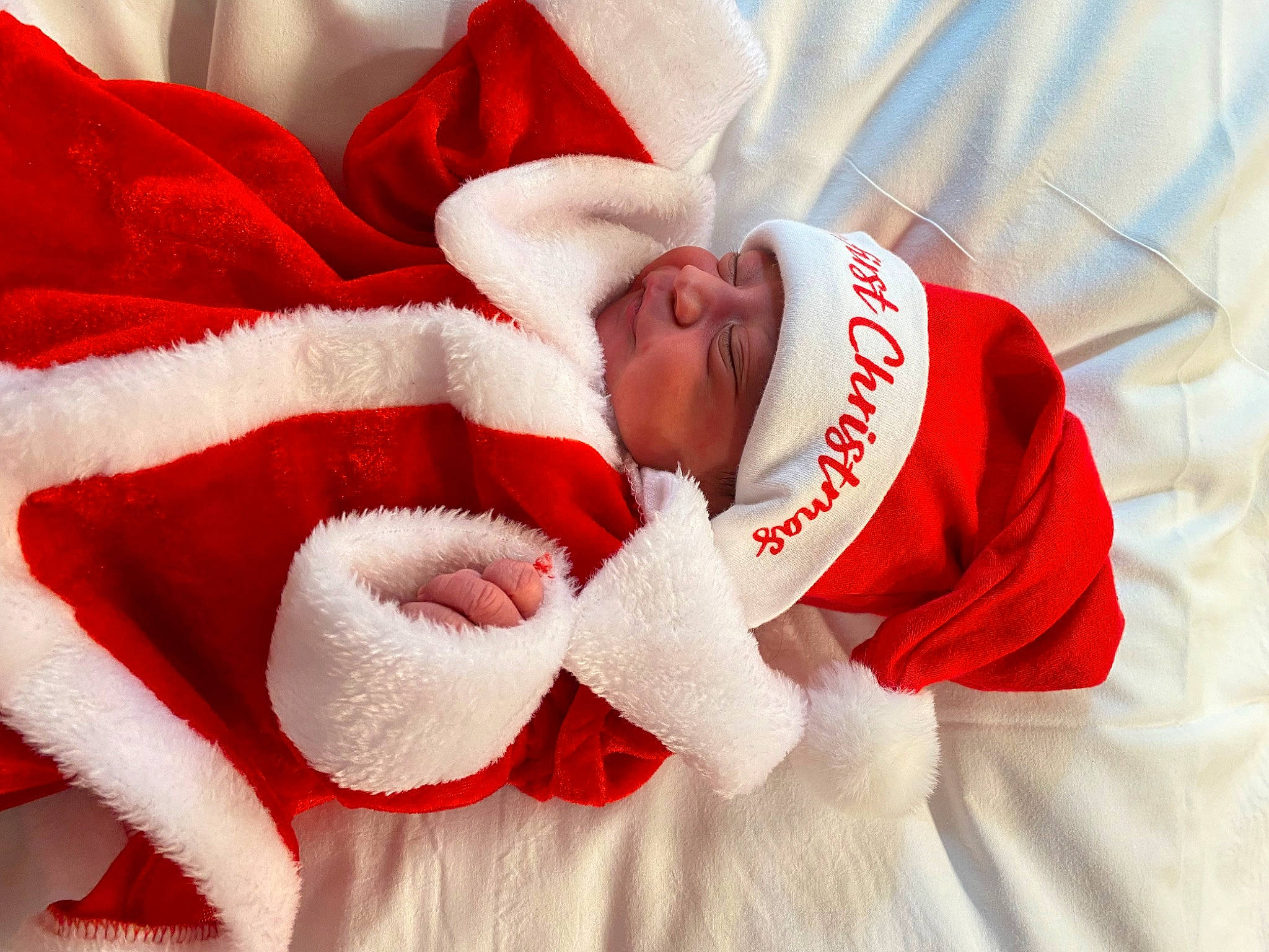 Amir is registered to the contest to win money with this photo: baby, baby_sleeping, baby_toddler_clothing, carmine, christmas, christmas_eve, comfort, event, fictional_character, font, fur, happy, headwear, holiday, linens, person, petal, red, santa_claus, sleeve