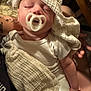 Rowan is registered to the contest to win money with this photo: baby, pacifier, blanket, sleeping, infant, arm, tattoo, clothing, person, resting, comfort, soft_texture, white_clothing, indoor, closeup, peaceful, human, skin, gentle, holding