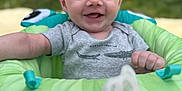 Rowan is registered to the contest to win money with this photo: baby, smiling, outdoor, seat, pacifier, clothing, child, happy, infant, face, person, green, blue, gray, grass, background, cute, joy, portrait, sitting