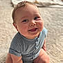 baby, child, smiling, sitting, blue_clothing, striped, onesie, carpet, indoors, cute, chubby, happy, face, head, infant, person, portrait, skin, soft_light, young