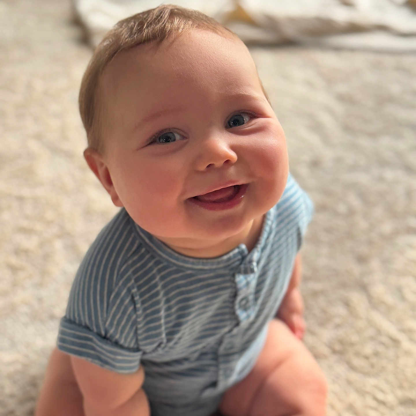 Lucas joined the competition — help win amazing prizes! baby, blue_clothing, carpet, child, chubby, cute, face, happy, head, indoors, infant, onesie, person, portrait, sitting, skin, smiling, soft_light, striped, young