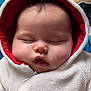 baby, infant, sleeping, hood, hoodie, reindeer_antlers, plush, zipper, chubby_cheeks, closed_eyes, portrait, close_up, soft_texture, cozy, cuddly, winter_clothing, adorable, indoor, face, skin