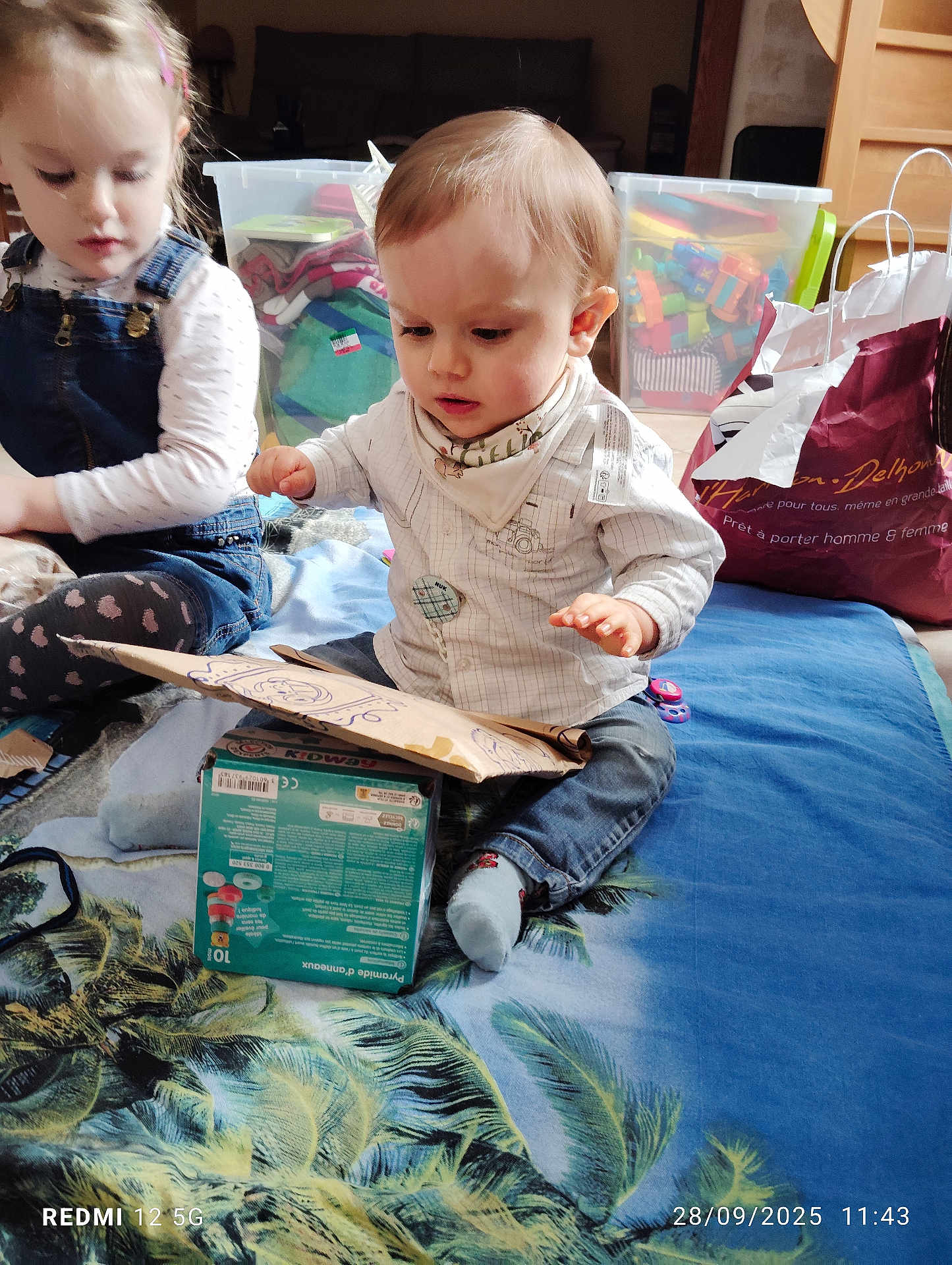 Tyago a rejoint le concours — aidez-le/la à gagner de superbes lots ! child, toddler, baby, indoor, playing, toy, box, blanket, clothing, socks, storage_bin, furniture, curious, floor, person, casual, home, cute, exploration, sitting