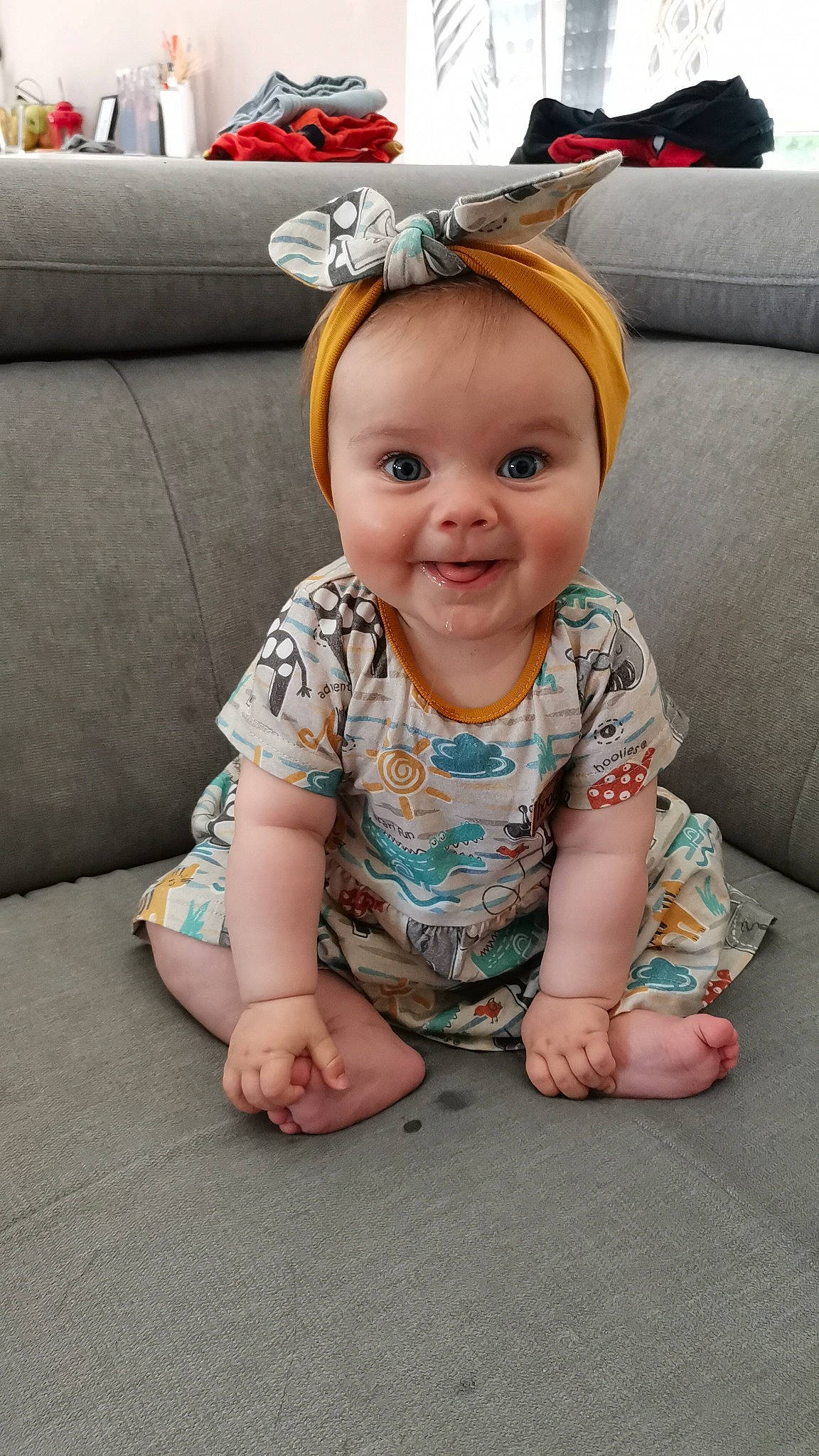 Alice participe au concours pour gagner de l'argent avec cette photo : baby, baby_toddler_clothing, cheek, child, comfort, couch, flooring, fun, grass, happy, joy, living_room, pattern, person, portrait_photography, room, sitting, sleeve, smile, t_shirt