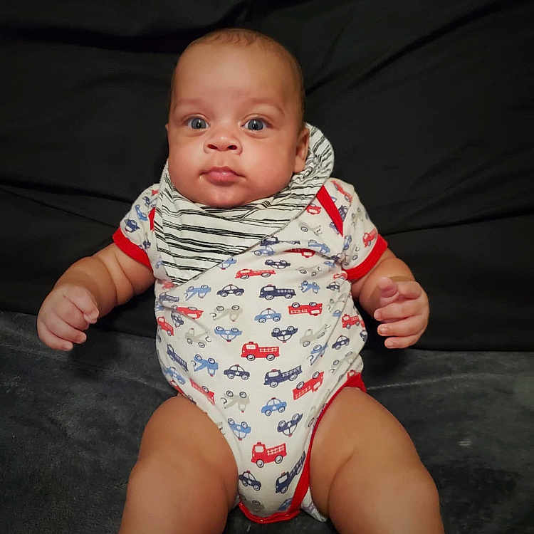 Elijah is registered to the contest to win money with this photo: baby, bodypart, bonnet, clothing, couch, crawling, diaper, face, finger, furniture, hand, happy, hat, head, newborn, person, photography, portrait, sitting, smile